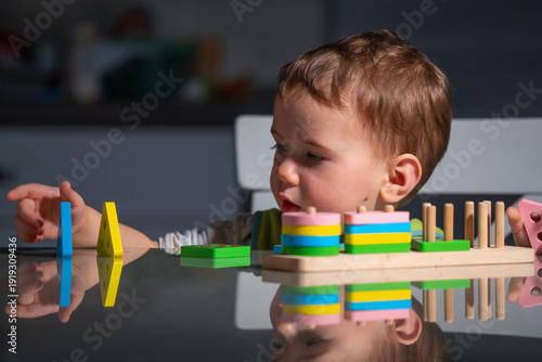 Obraz na plátně Toddler focused on developmental play, strengthening finger movements and coordination