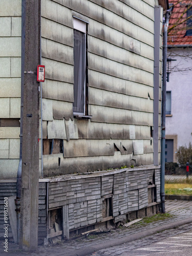 Defekte und feuchte Wandverkleidung mit Asbest