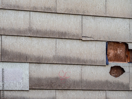 Defekte und feuchte Wandverkleidung mit Asbest