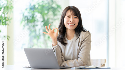 Принти на полотні ノートパソコンの前でOKサインを見せる女性ビジネスパーソン, Businesswoman showing OK sign in front of laptop