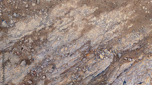 Fotografija Aerial view of a rugged arid terrain with natural striped patterns and scattered