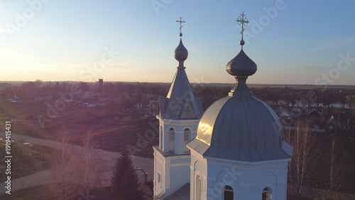 Foto Aerial view of an orthodox church in a rural landscape at sunset