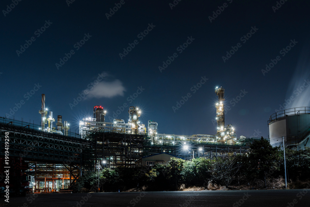 Fototapeta premium Industrial Complex Lit Against Night Sky, Chemical Processing Site