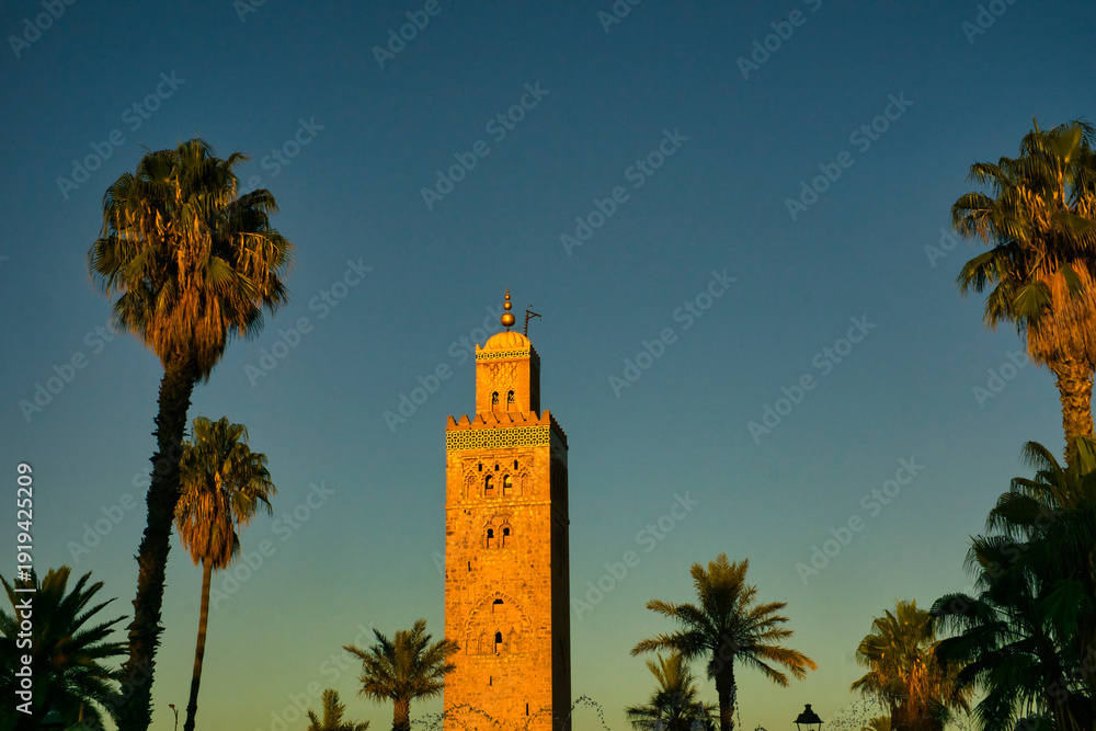 Fototapeta premium Iconic Koutoubia Mosque during golden hour under a clear blue sky, Marrakech, Morocco