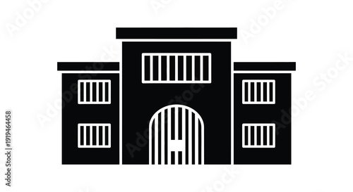 Simple black prison building facade with arched doorway a striking silhouette