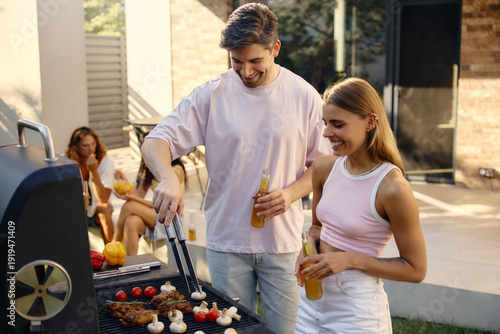 Cuadro en lienzo Young couple grilling food at summer backyard barbecue
