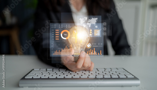 Fotografija Business professional holding light bulb with glowing elements above keyboard showcasing innovative ideas, data analysis, and technological advancement concepts Scalp