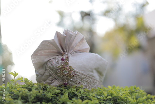 Traditional Indian Groom Turban with Decorative Brooch on Green Background