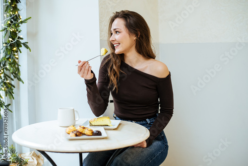 Young woman enjoys dessert ...