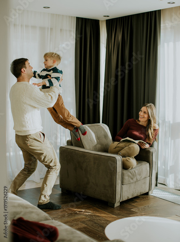 Man lifts child in living r...