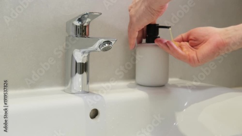 Hands, washing and faucet with water flow for hygiene, cleanliness and personal care in bathroom. Soap dispenser, sink and daily routine for health.