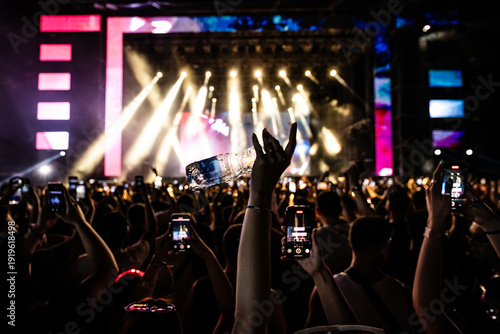 Photography Crowd holding smartphones recording live music concert and throwing water bottle