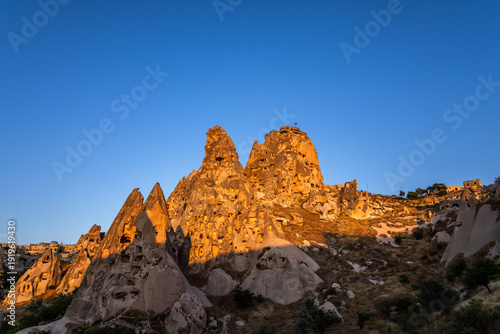 Uchisar castle, a settlement carved in a huge volcanic rock for defence, at sunset. Cappadocia, Turkey.