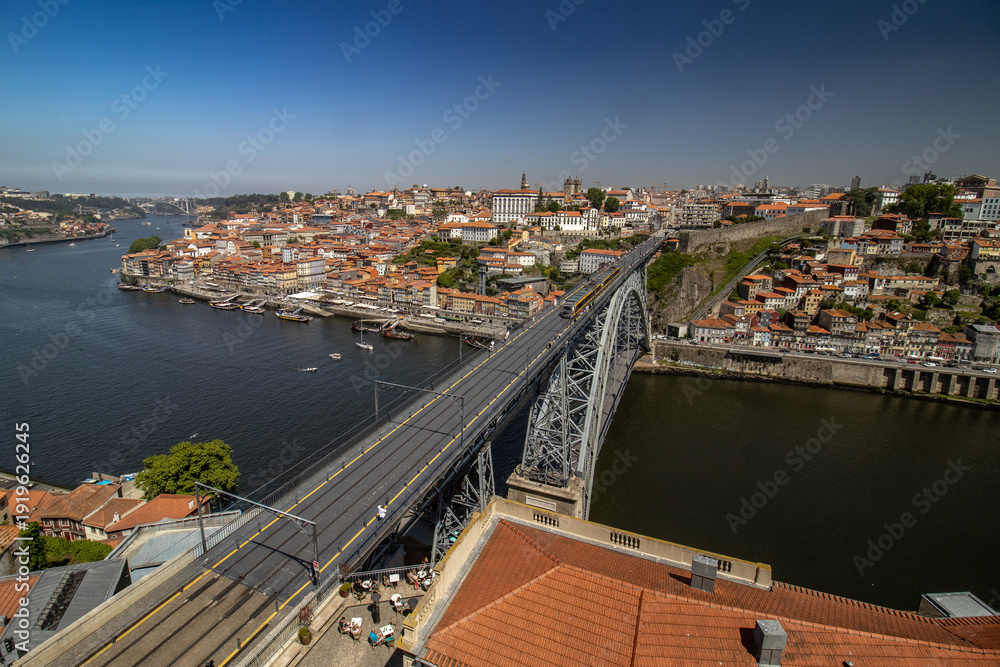 Φωτογραφία Paisaje urbano del centro de Oporto con sus característicos tejados rojos y la Torre de los Clérigos destacando bajo un cielo azul