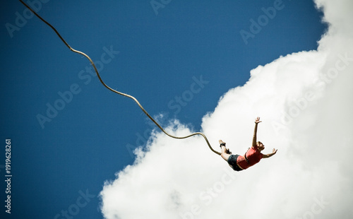 Canvas Print woman bungee jumping against blue sky