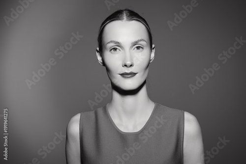 Foto Portrait of a young Caucasian woman with light skin and tied back hair wearing a sleeveless top, looking confidently at the camera in black and white