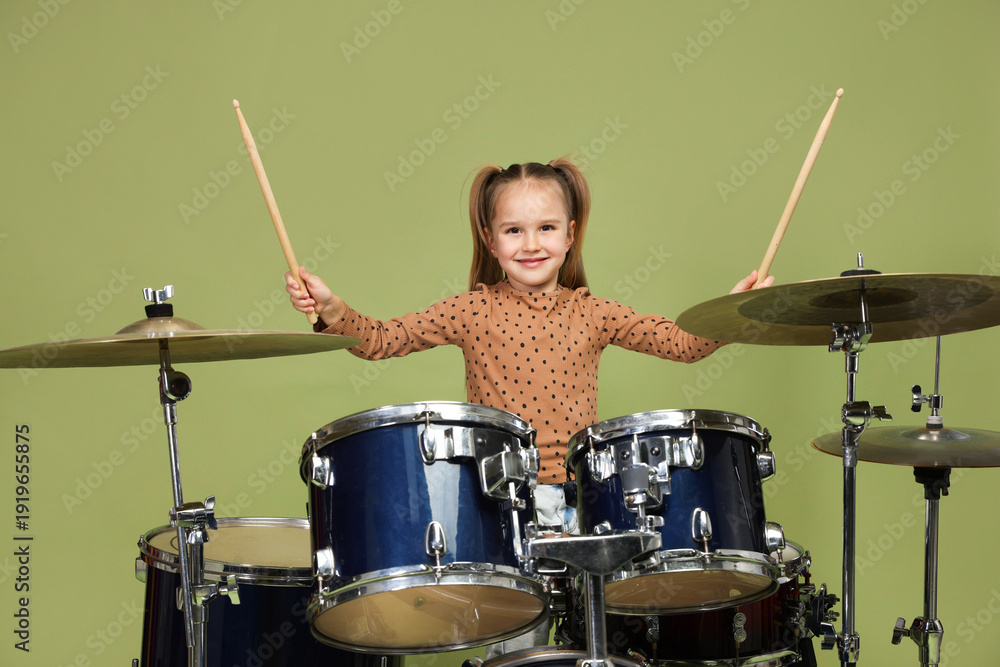 Ταπετσαρία Little girl learning how to play drums on green background