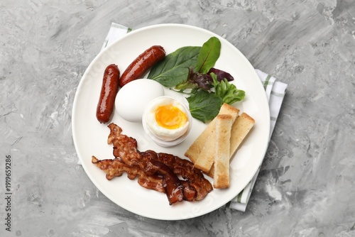 Wallpaper Mural Tasty breakfast with soft boiled eggs, bacon, sausages, toasted bread and salad on grey table, top view Torontodigital.ca