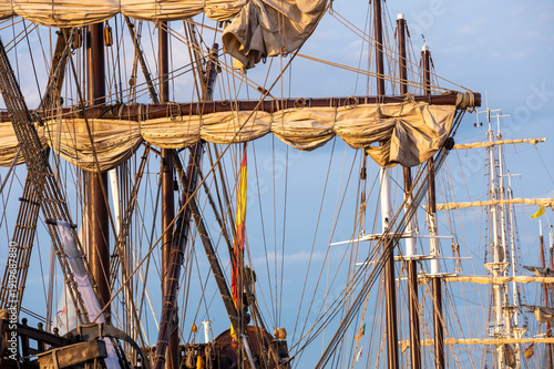 Spanish historical ship rigging and furled sails at sunrise