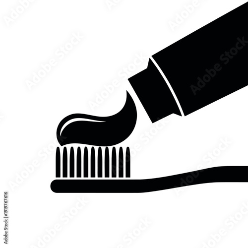 Toothpaste squeezes onto a toothbrush bristles in a dark silhouette representing.