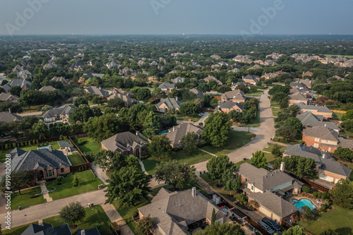 Foto Aerial Drone View of Houses Along Street in Neighborhood Surrounded by Trees in