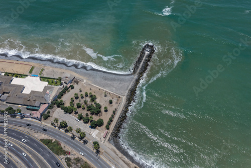 Foto Aerial view of rock breakwater and highways alongside cliffs and ocean