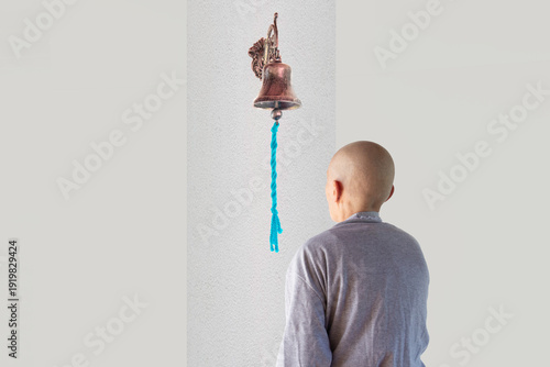 Woman looking at the bell of hope in the chemotherapy room.