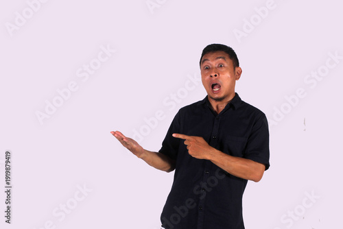 An Asian adult man wearing a black shirt smiles happily after getting a new idea, with a pose of opening both hands and showing his idea.