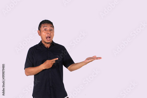An Asian adult man wearing a black shirt smiles happily after getting a new idea, with a pose of opening both hands and showing his idea.
