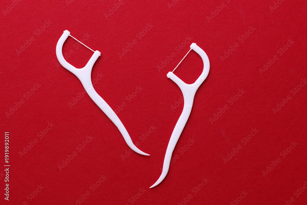 Fotografi Floss toothpicks on red background