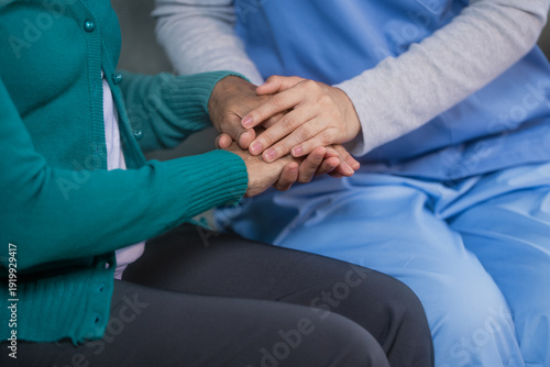 Cuadro en lienzo nurse gently holds hands with an elderly female cancer patient at home, offering