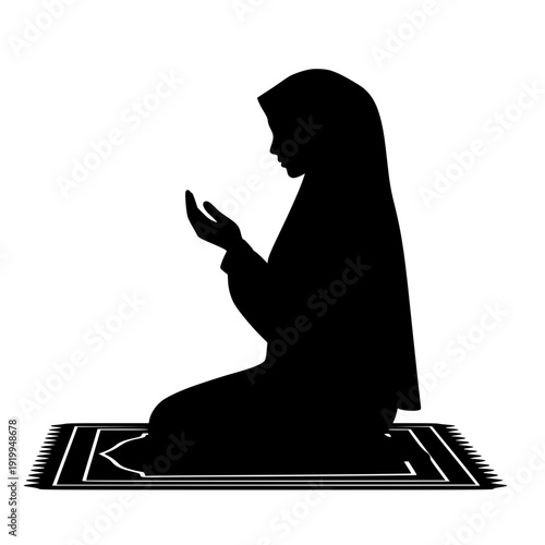 Silhouette of woman praying on prayer mat