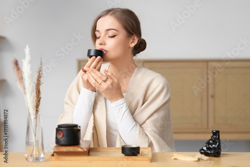 Beautiful young woman drink...