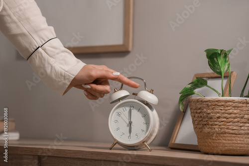 Young woman turning off ala...