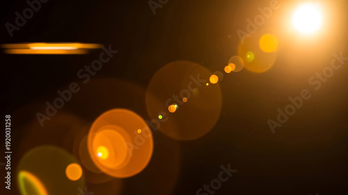 Bright orange lens flare effect with glowing circles and light streaks on a dark background, symbolizing optimism and new beginnings.