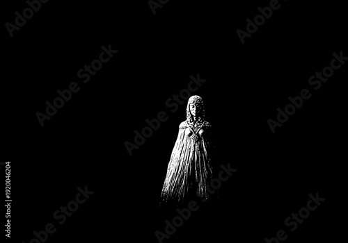 Mysterious woman in a long dress standing alone.