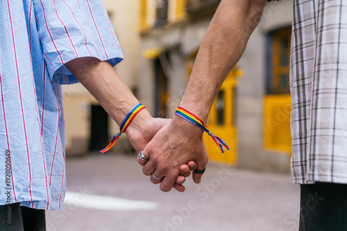 Bild auf Leinwand Two people wearing rainbow bracelets and holding hands, showing love, support, c
