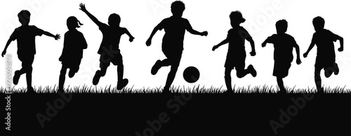 Silhouette of children playing soccer on a grassy field, young boys and girls running after a football, active childhood sports and recreation.