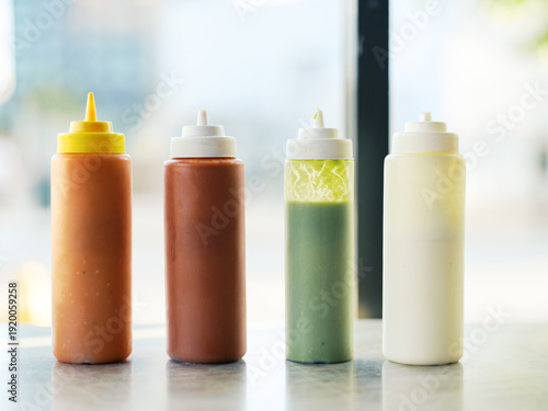 Obraz na płótnie Four squirt bottles of different Taco salsas and sauces