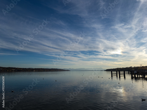 Wide lake view with distant alpine mountains and soft evening glow