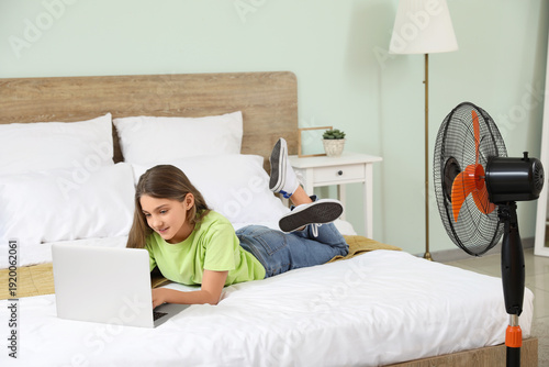 Teenage girl lying on bed w...