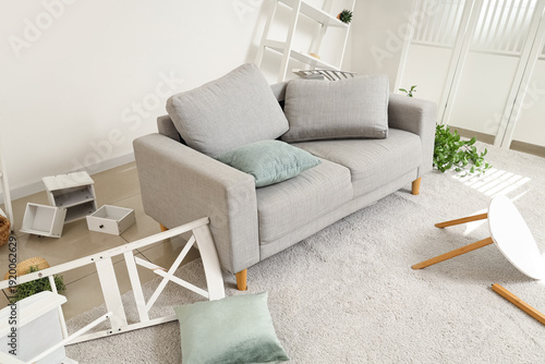 Konstfotografi Sofa with overturned things in messy living room