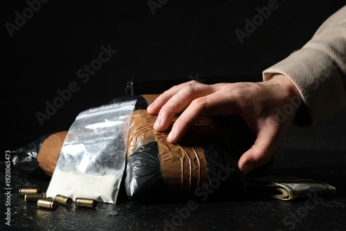 Fotografía Man with drug packages and money on dark background, closeup