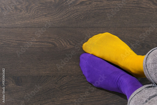 Quadro su tela Close up mismatched yellow and purple socks with copy space, World Down Syndrome