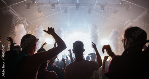 Cheering crowd with hands raised at concert. Summer and festival vibes