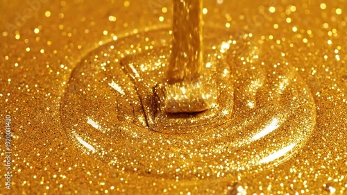Viscous golden liquid with shimmering glitter particles flowing and creating ripples on a sparkling gold surface abstract luxury background.