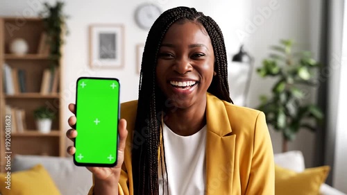 Woman holding phone with green screen.