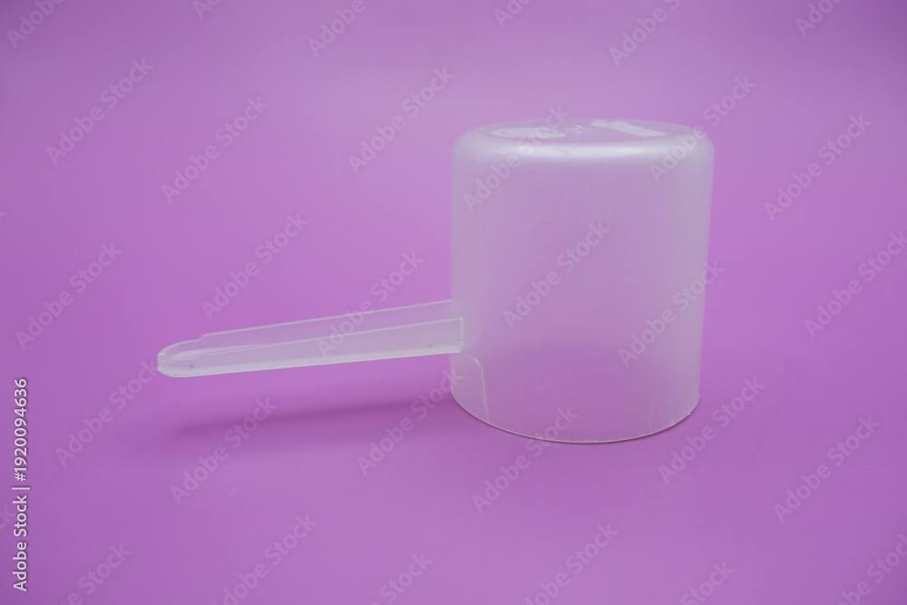 Obraz premium Transparent Plastic Scoop on Purple Background