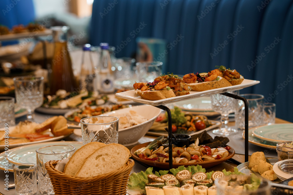 Fototapeta premium Elegant Buffet Spread with Fresh Appetizers, Bread, and Beverages on a Stylish Table Setting