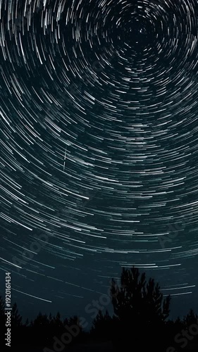 Time lapse of Star trails in the night sky. Stars move around a polar star, vertical footage